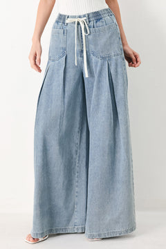 Woman wearing a light blue denim wide-leg pants with a drawstring waist | FREEMARKET