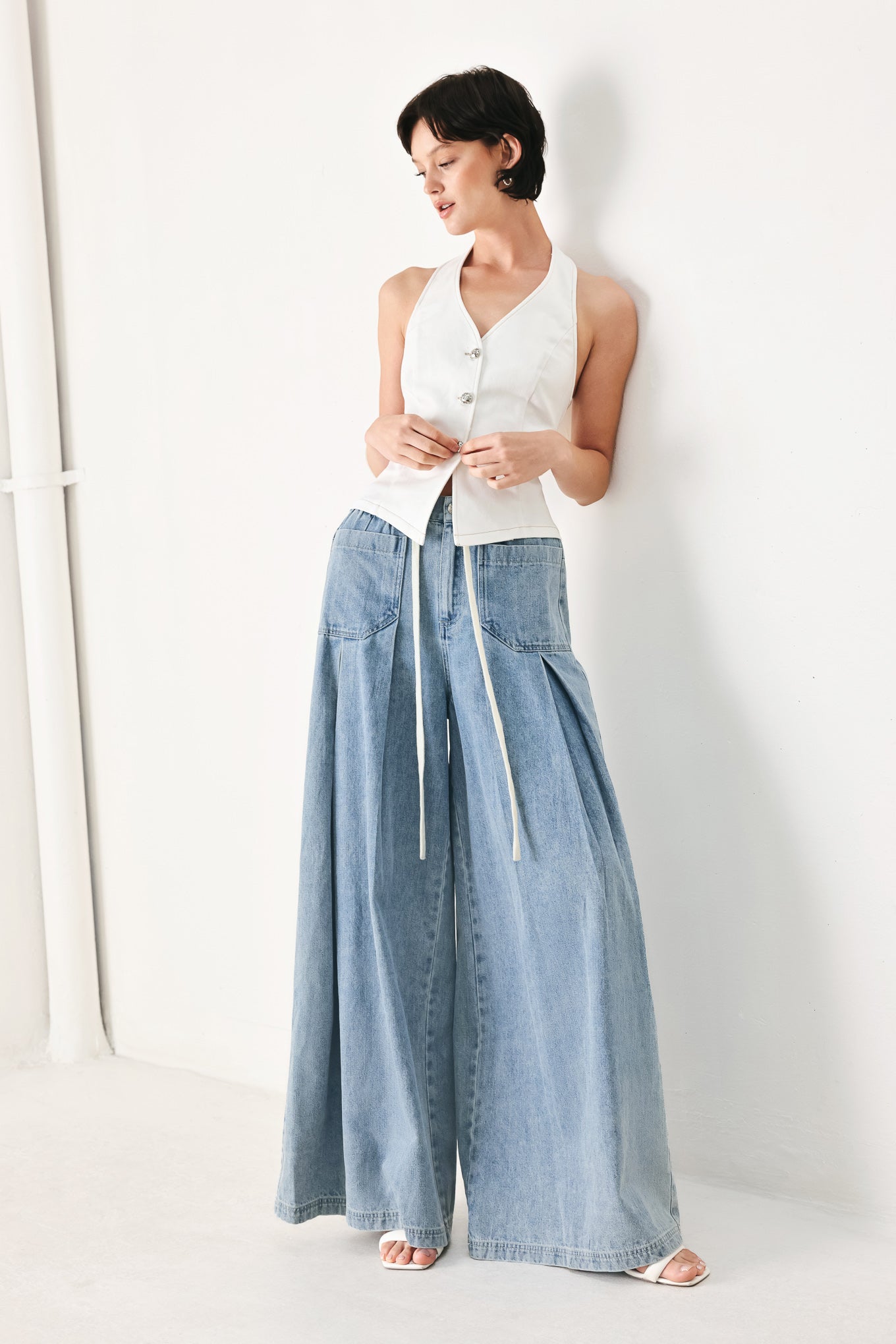 Woman wearing a light blue denim wide-leg pants with a drawstring waist | FREEMARKET