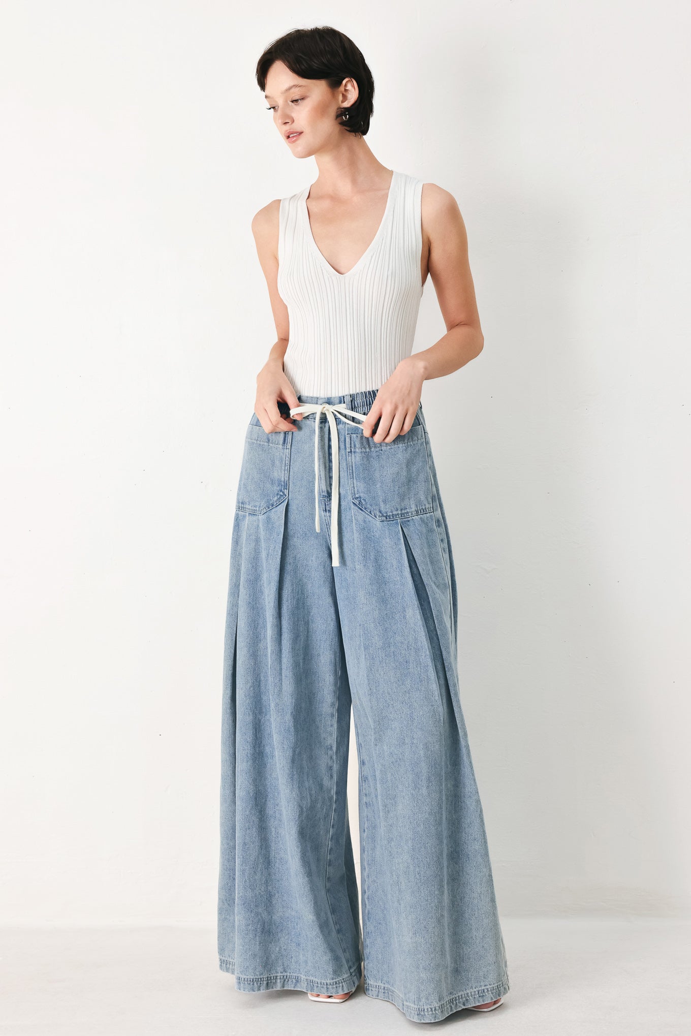 Woman wearing a light blue denim wide-leg pants with a drawstring waist | FREEMARKET