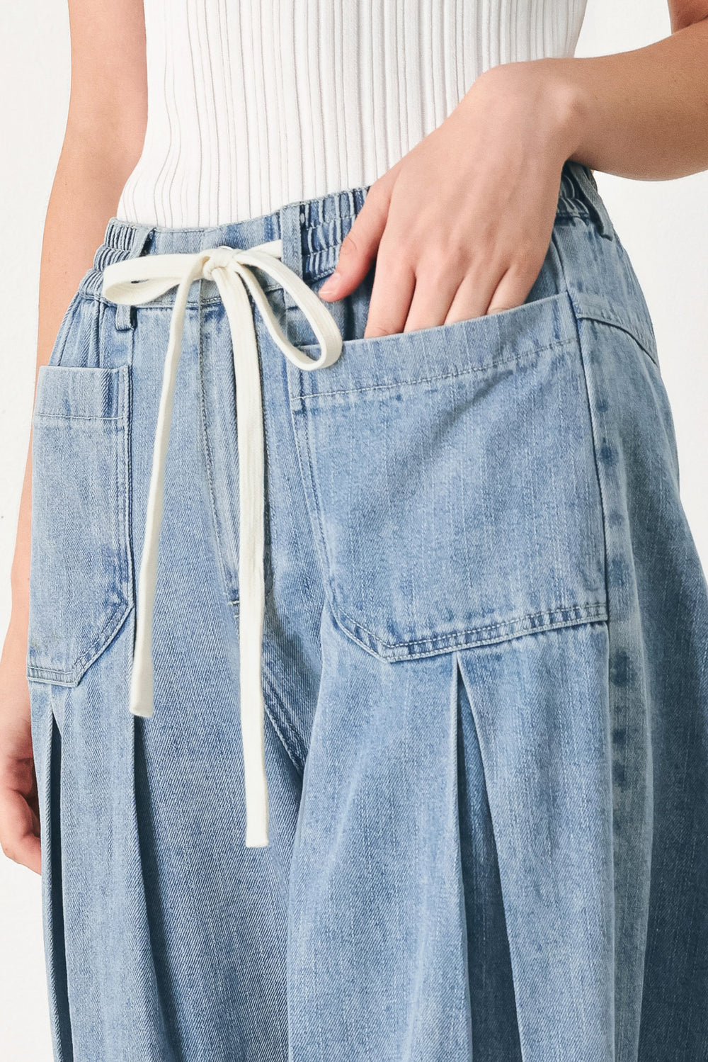 Woman wearing a light blue denim wide-leg pants with a drawstring waist | FREEMARKET