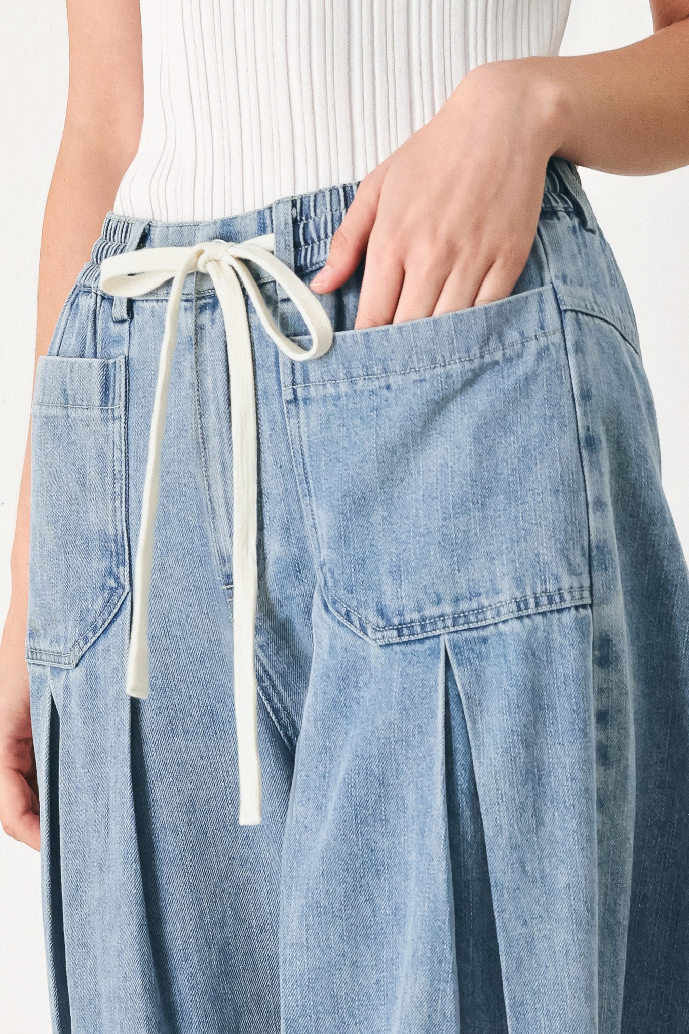 Woman wearing a light blue denim wide-leg pants with a drawstring waist | FREEMARKET