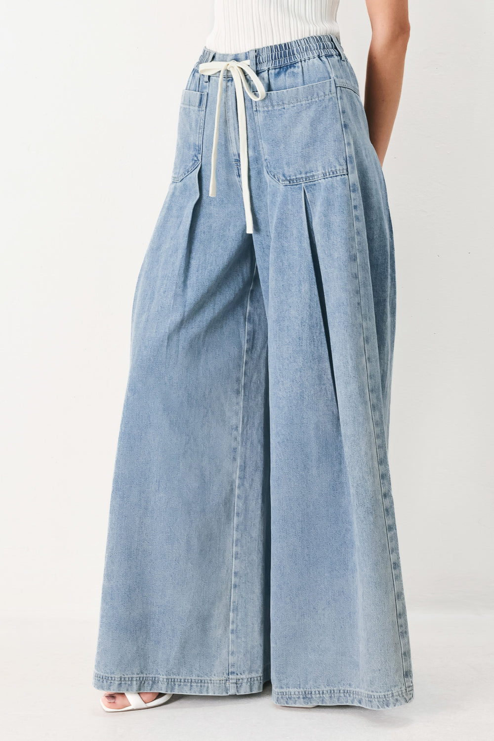 Woman wearing a light blue denim wide-leg pants with a drawstring waist | FREEMARKET