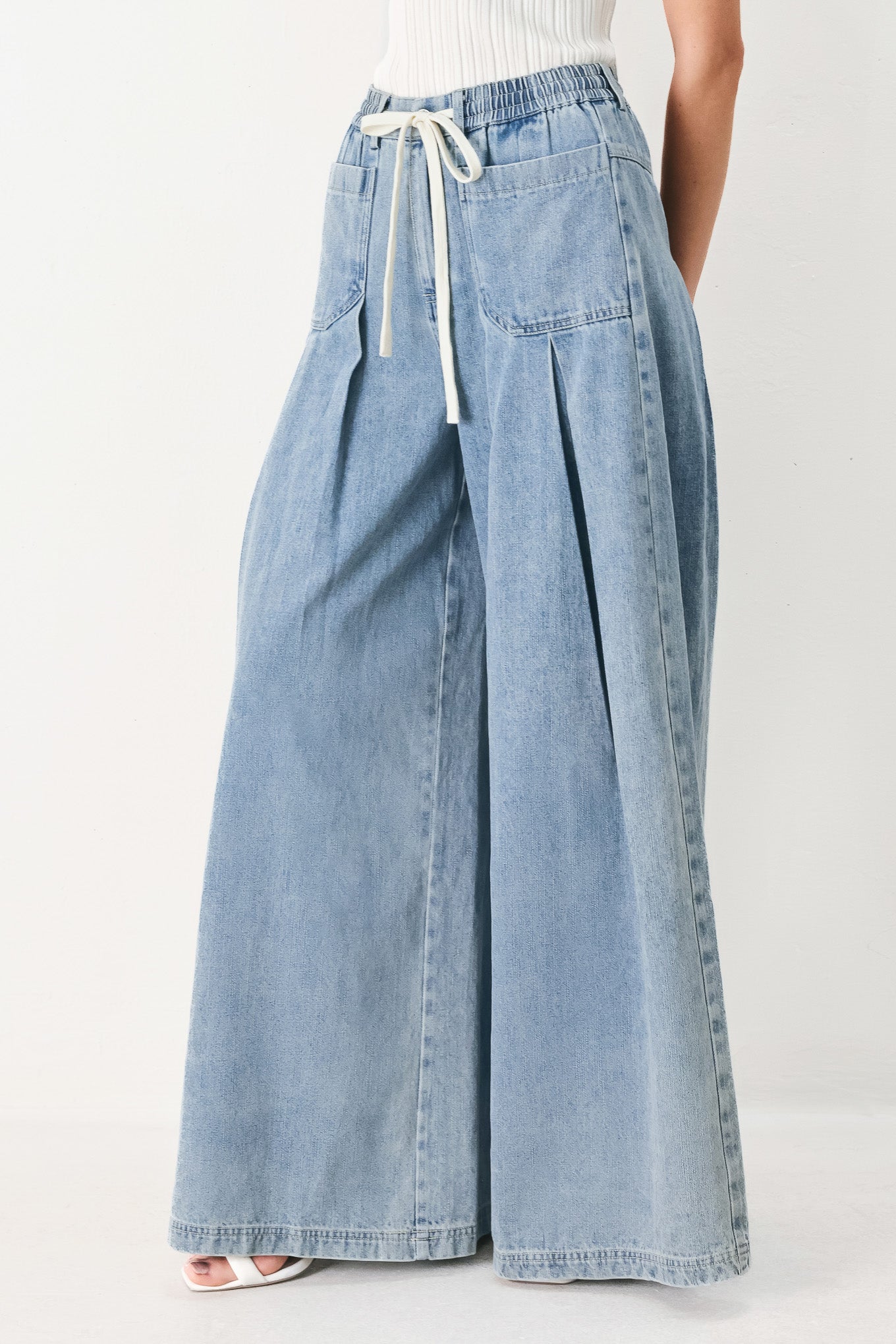 Woman wearing a light blue denim wide-leg pants with a drawstring waist | FREEMARKET