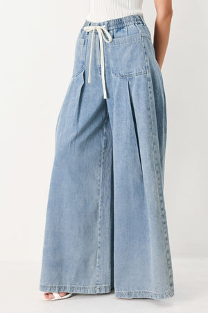 Woman wearing a light blue denim wide-leg pants with a drawstring waist | FREEMARKET