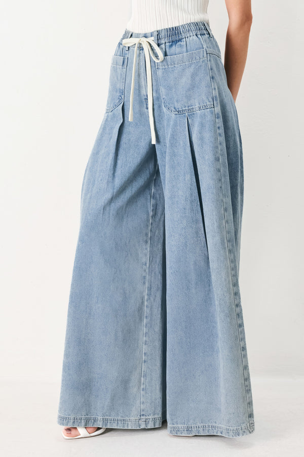 Woman wearing a light blue denim wide-leg pants with a drawstring waist | FREEMARKET