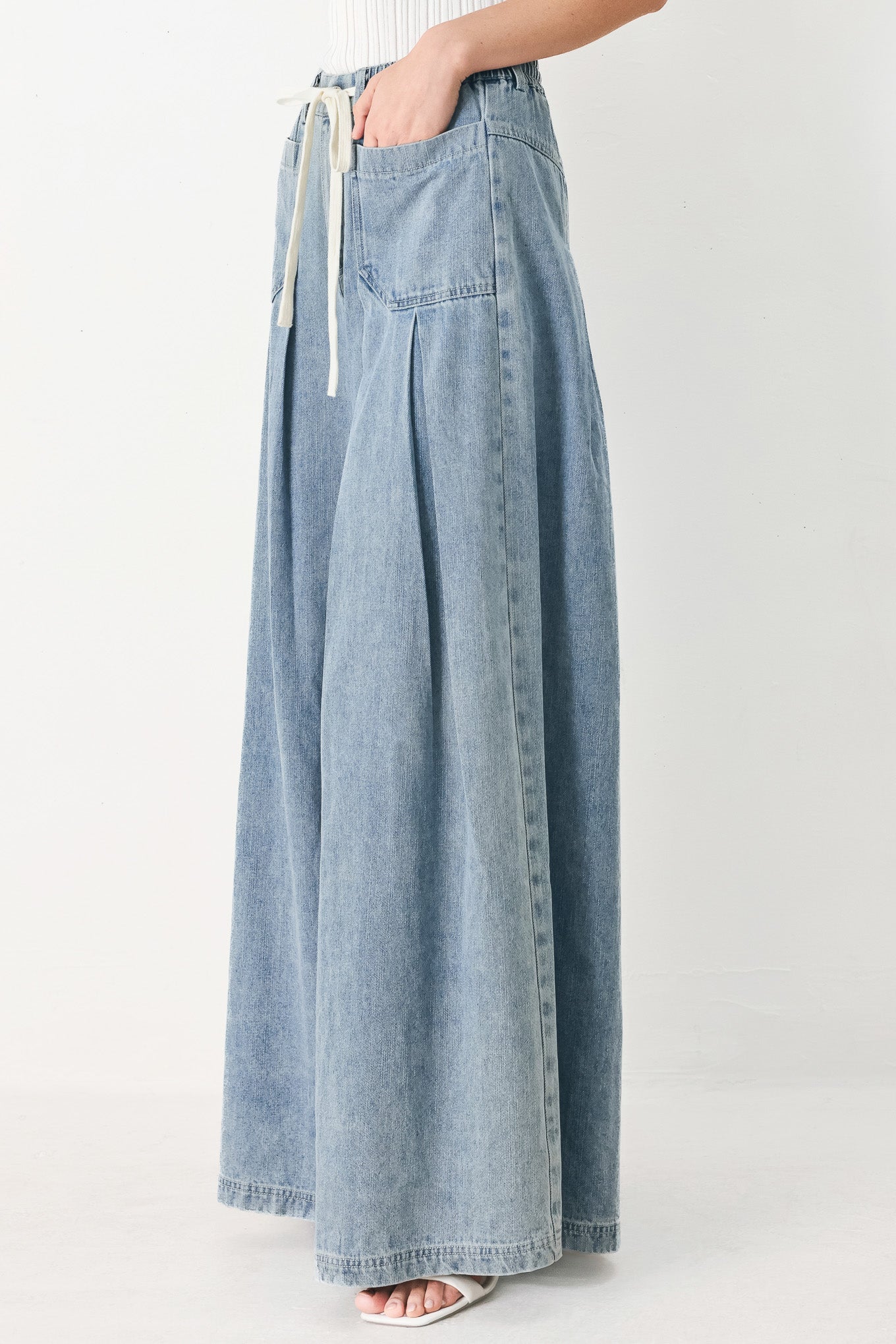 Woman wearing a light blue denim wide-leg pants with a drawstring waist | FREEMARKET
