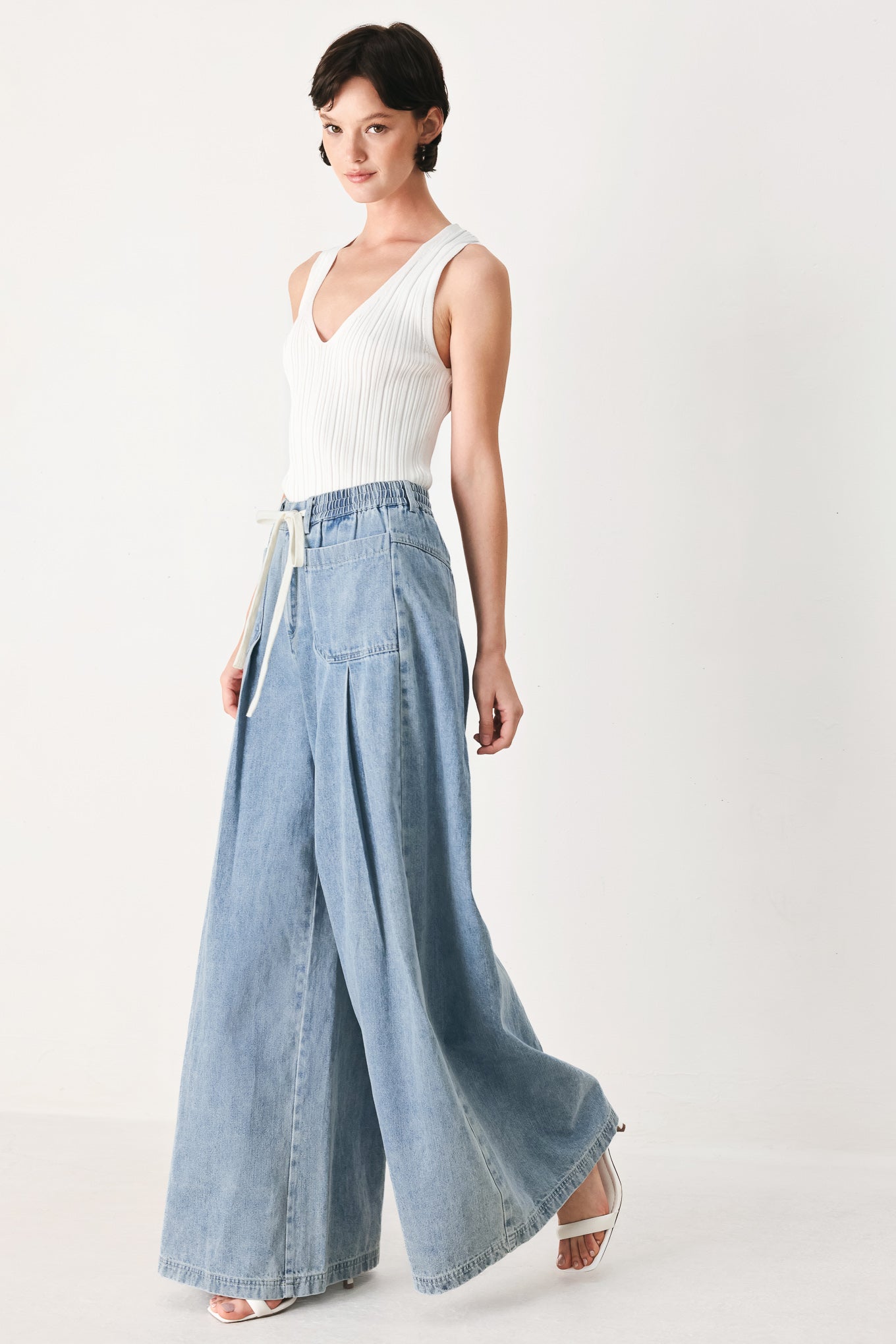 Woman wearing a light blue denim wide-leg pants with a drawstring waist | FREEMARKET