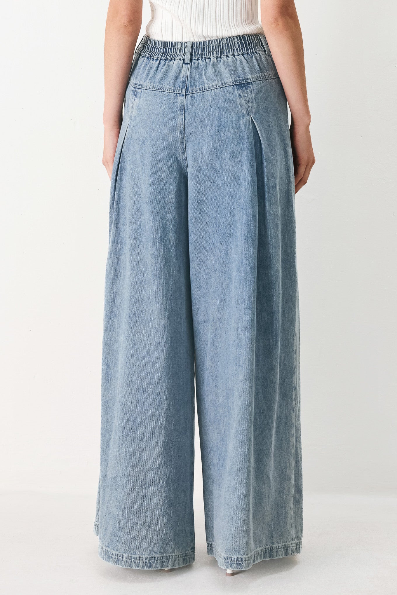 Woman wearing a light blue denim wide-leg pants with a drawstring waist | FREEMARKET