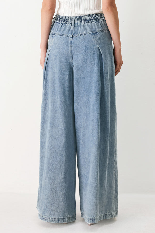 Woman wearing a light blue denim wide-leg pants with a drawstring waist | FREEMARKET