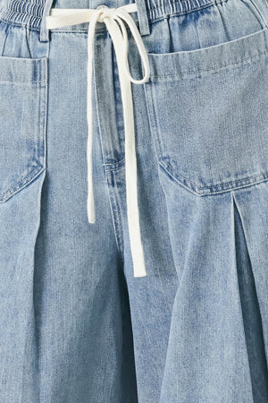 Woman wearing a light blue denim wide-leg pants with a drawstring waist | FREEMARKET
