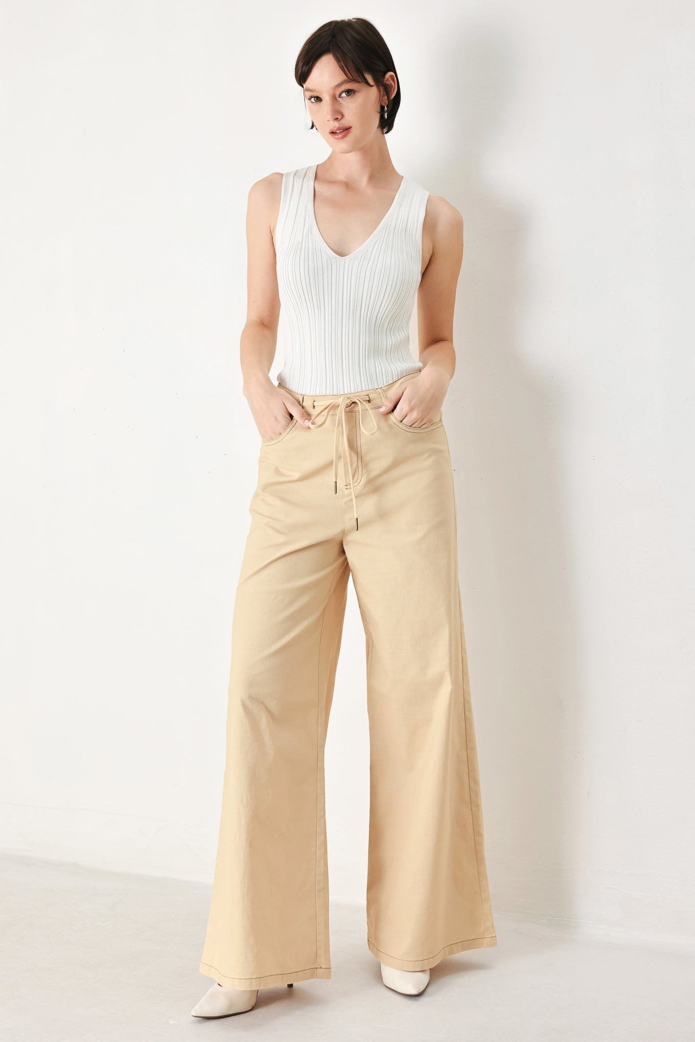 A solid woven pant featuring front closure, contrasting tie, pockets and wide leg