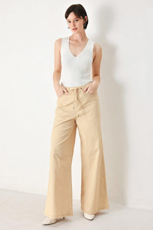 A solid woven pant featuring front closure, contrasting tie, pockets and wide leg