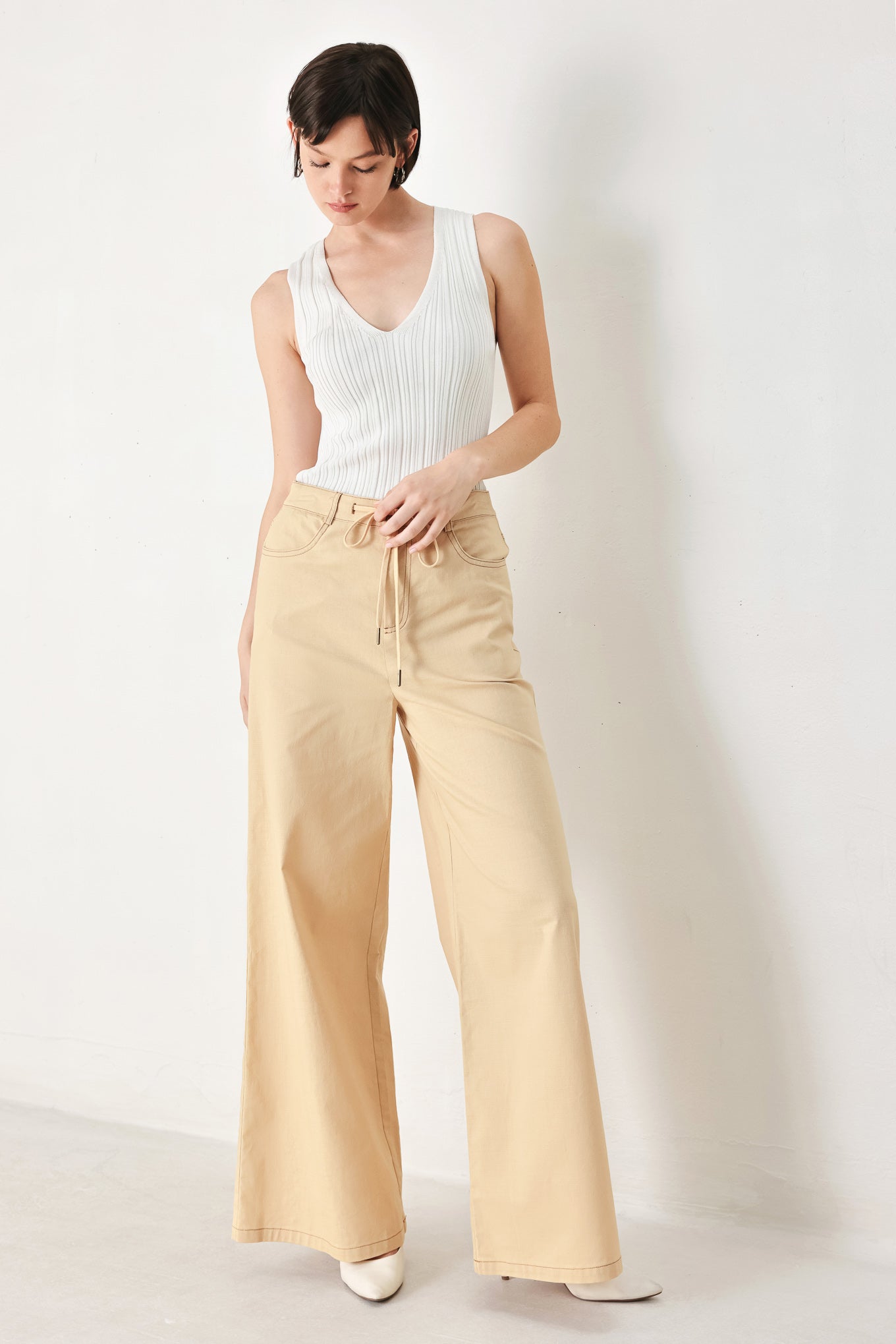 A solid woven pant featuring front closure, contrasting tie, pockets and wide leg