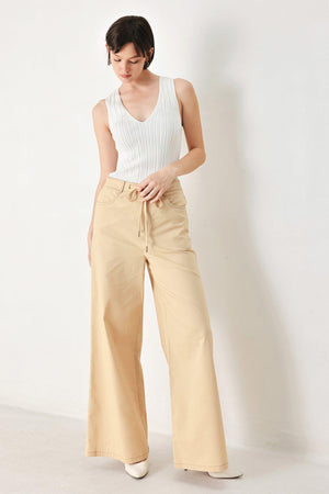 A solid woven pant featuring front closure, contrasting tie, pockets and wide leg