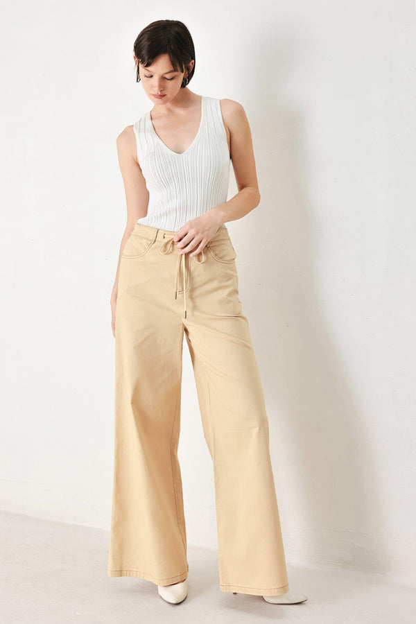 A solid woven pant featuring front closure, contrasting tie, pockets and wide leg