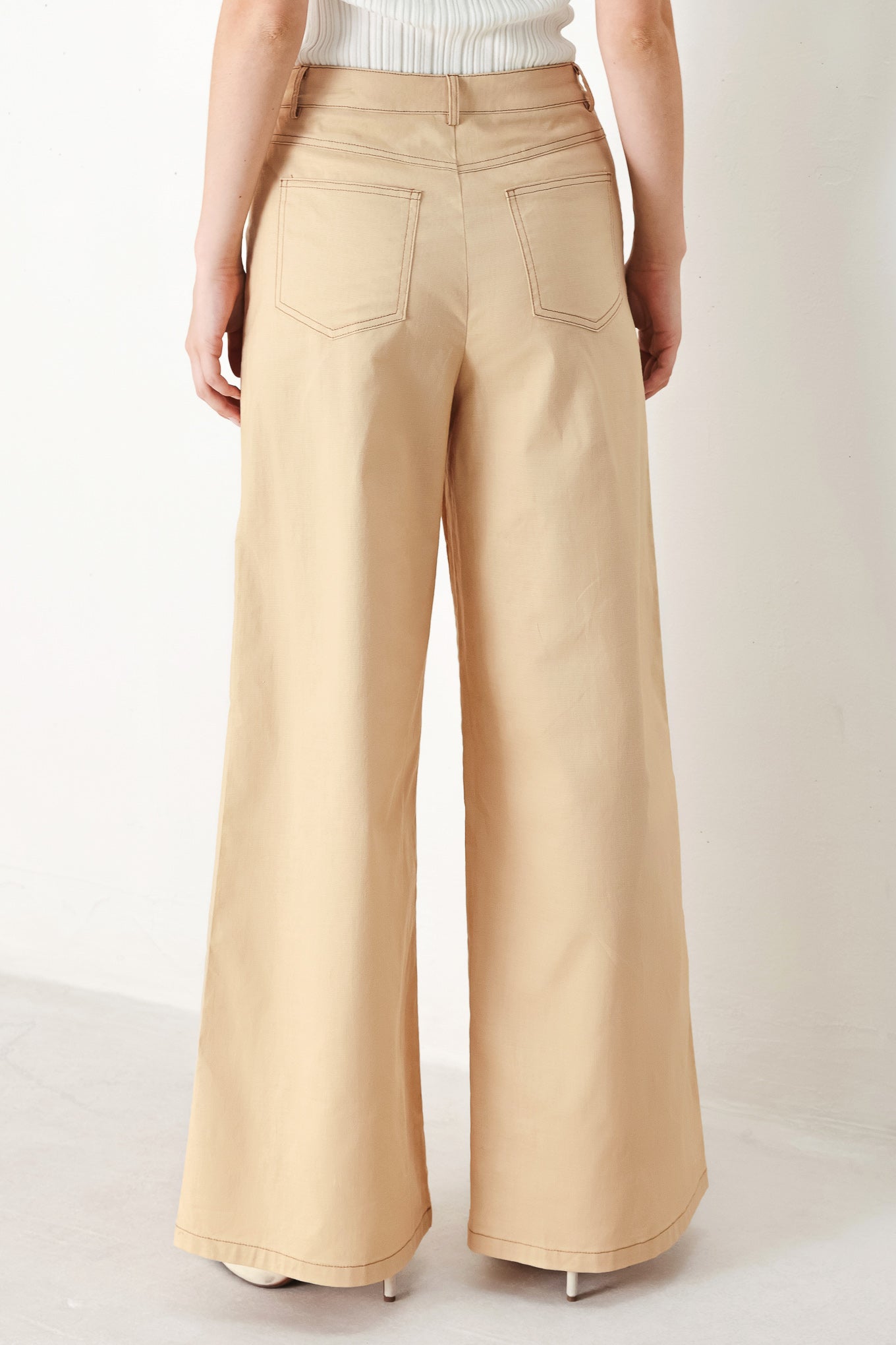 A solid woven pant featuring front closure, contrasting tie, pockets and wide leg