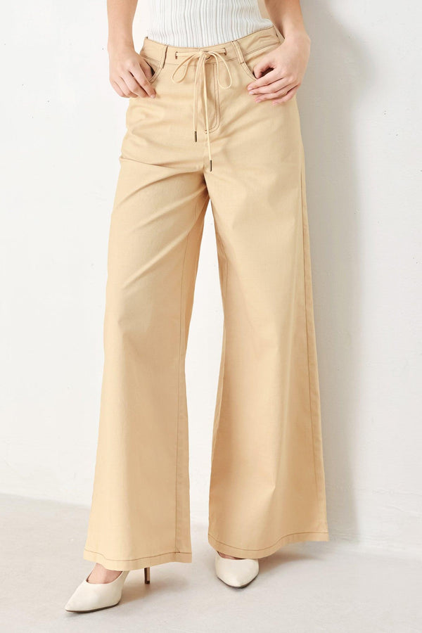 A solid woven pant featuring front closure, contrasting tie, pockets and wide leg