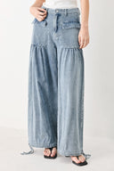 Woman wearing washed denim pants featuring front closure, front pockets, balloon leg with bottom tie | FREEMARKET