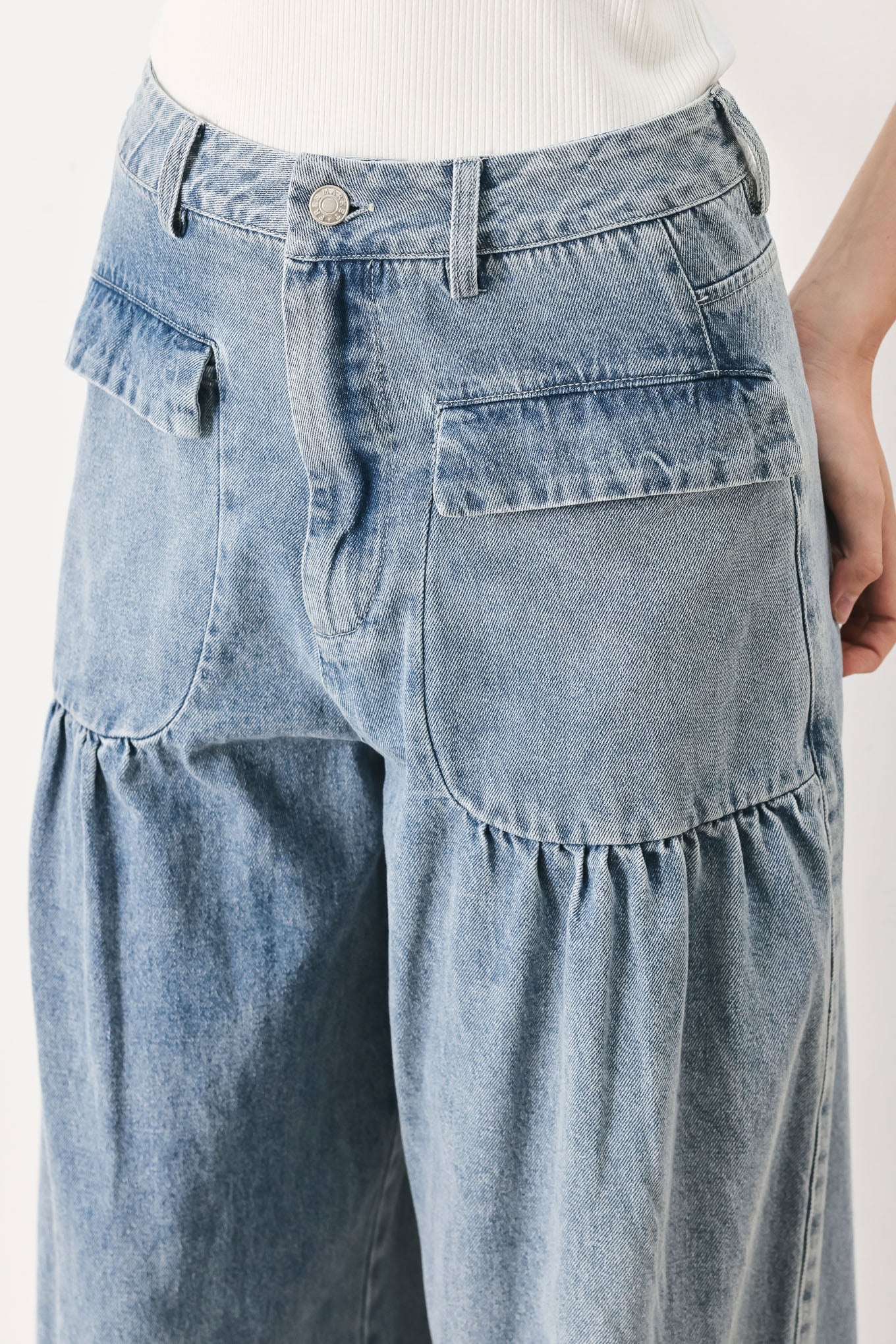Woman wearing washed denim pants featuring front closure, front pockets, balloon leg with bottom tie | FREEMARKET