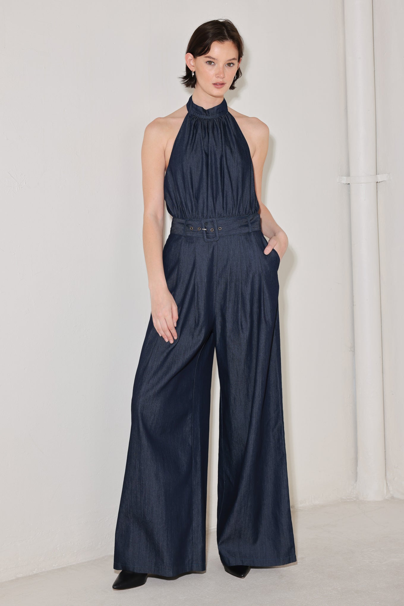 
A solid woven jumpsuit featuring halter neckline, self belt, wide leg, back neck button closure, bare back with straps and zipper closure

Details:

Self : 72% Cotton 28% Polyester
Lining : 100% Polyester

Size &amp; Fit

- Model is 5`8" And Wearing Size Small
- Measurements Taken From Size Small
- Approx. Length: 61"