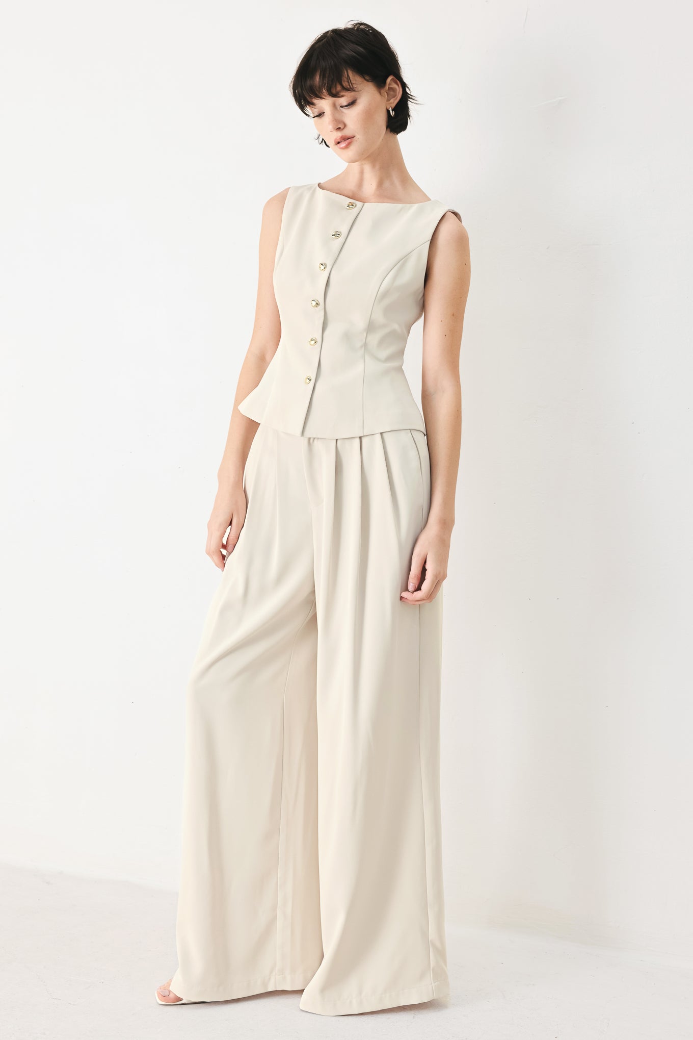 Woman wearing ivory woven wide-leg pants with front closure and pleated front | FREEMARKET