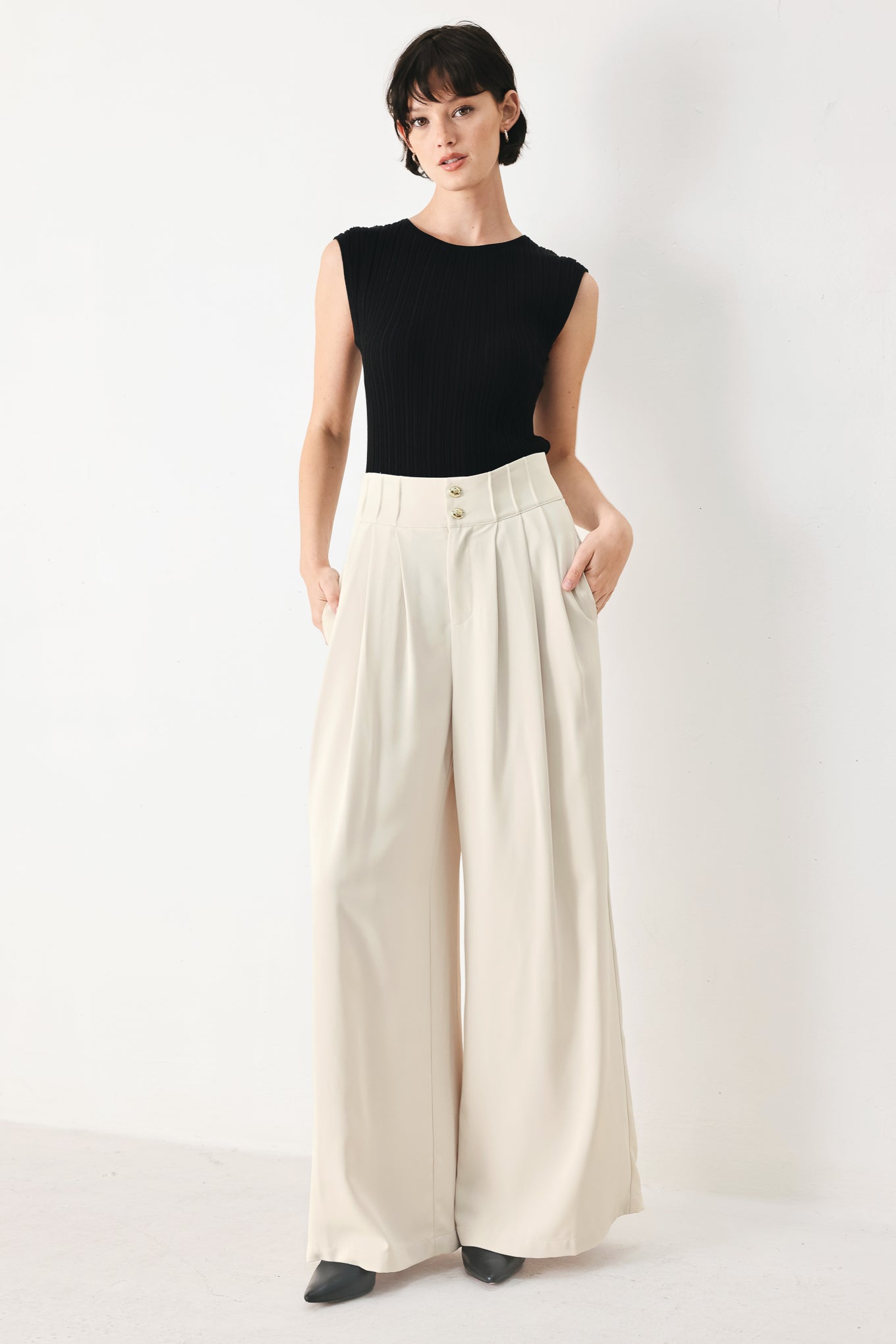Woman wearing ivory woven wide-leg pants with front closure and pleated front | FREEMARKET