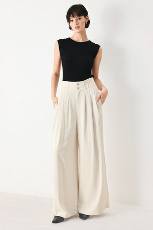 Woman wearing ivory woven wide-leg pants with front closure and pleated front | FREEMARKET