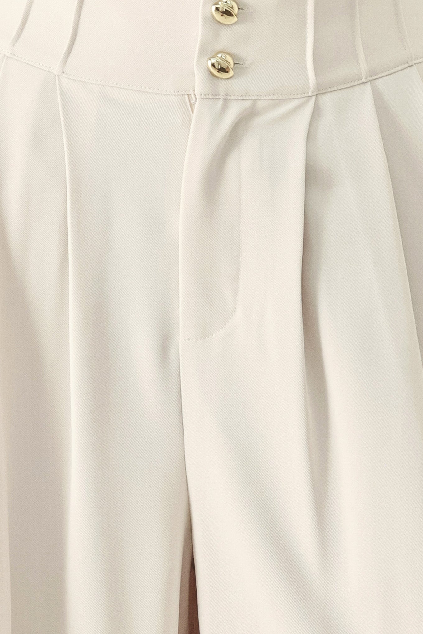 Close up of an ivory woven wide-leg pants with front closure and pleated front | FREEMARKET