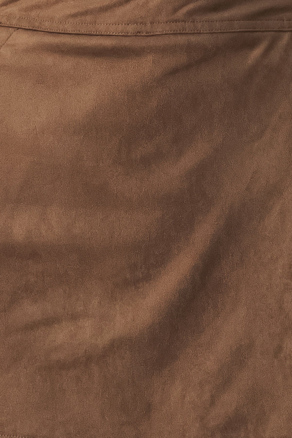 A brown wrap-style mini skort with decorative metallic buttons on the side, shown on a model | FREEMARKET