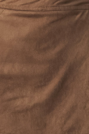 A brown wrap-style mini skort with decorative metallic buttons on the side, shown on a model | FREEMARKET