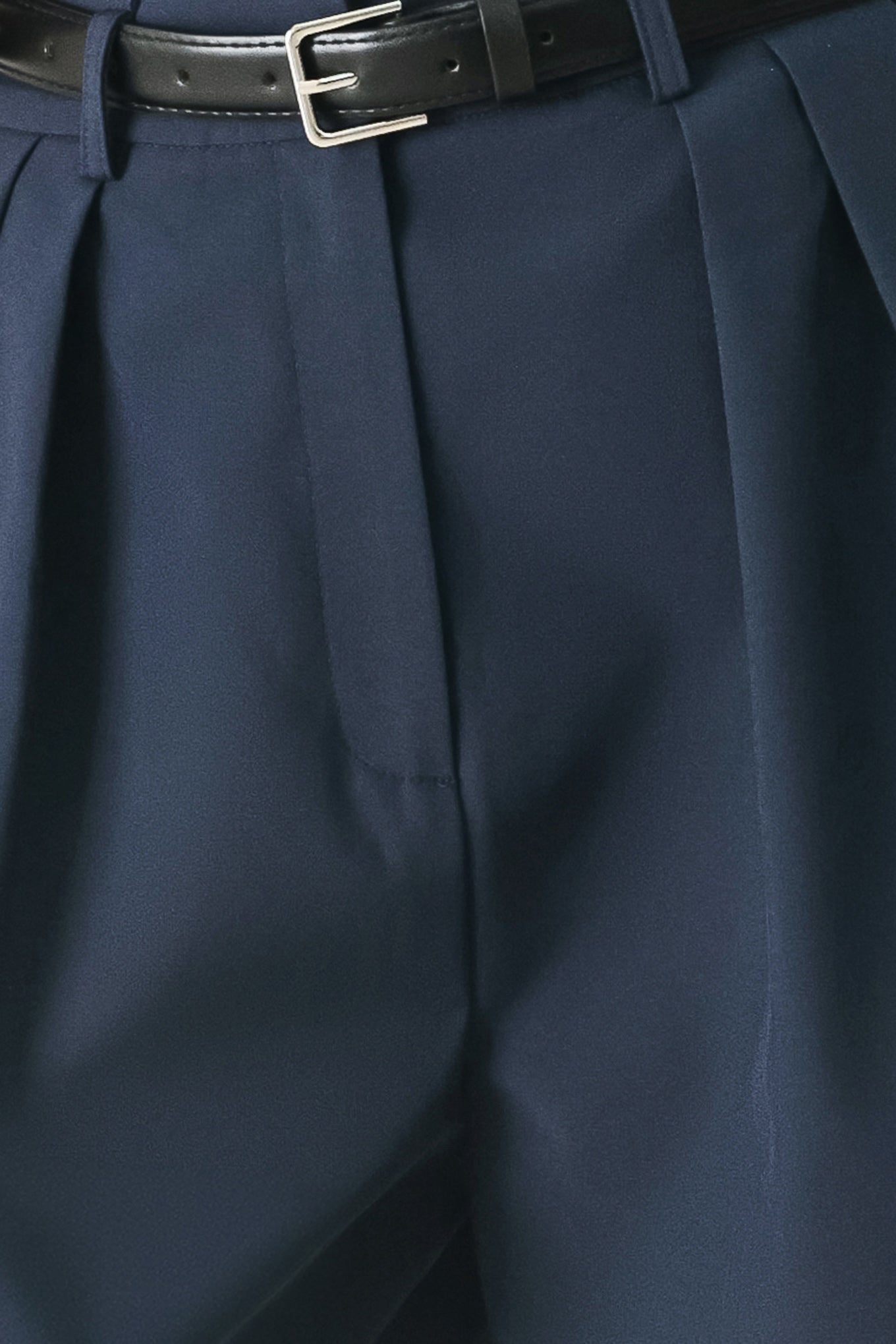 Woman wearing navy pleated pants with a black belt | FREEMARKET
