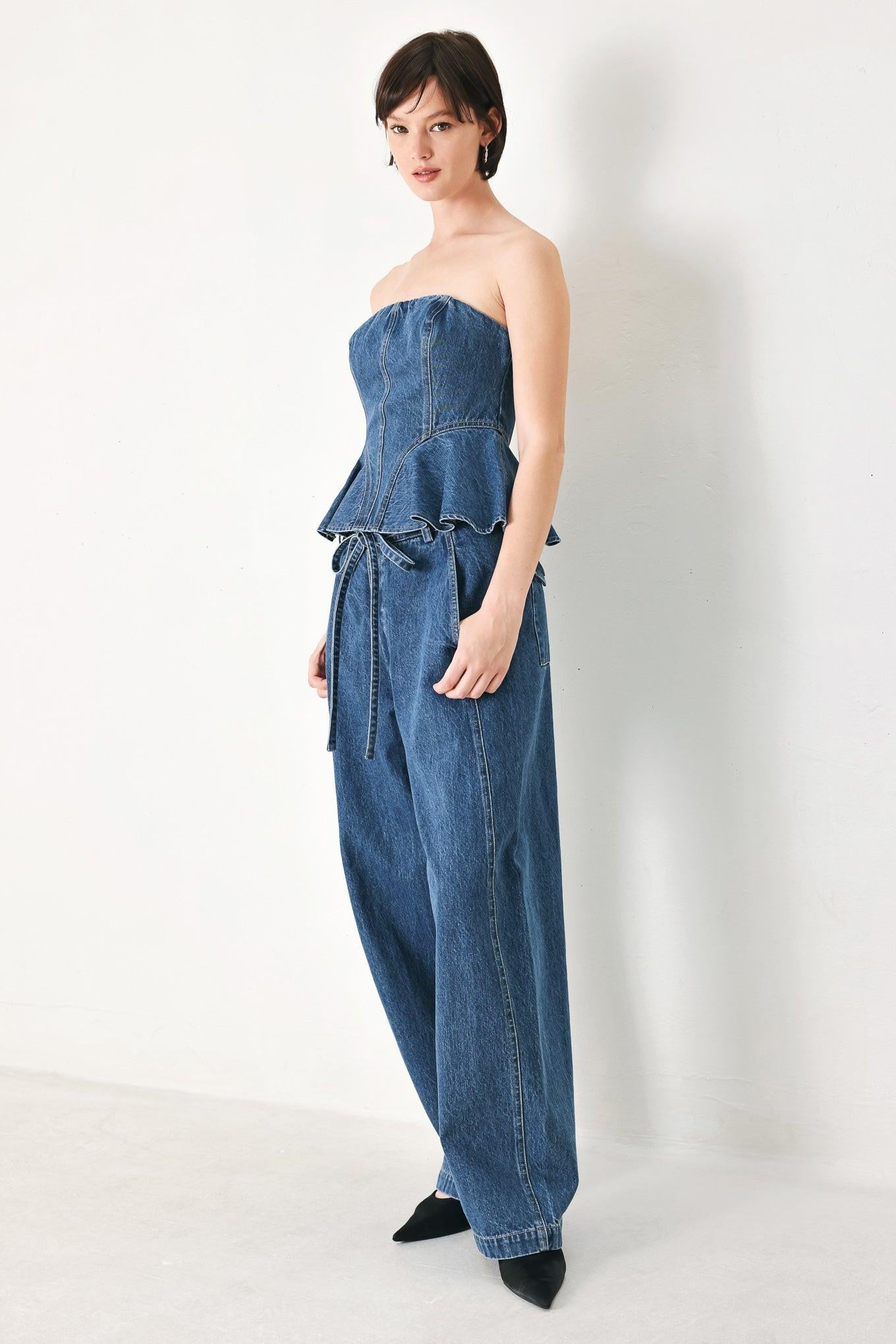 A washed oversized denim pant featuring front closure, side/back pockets and wide leg