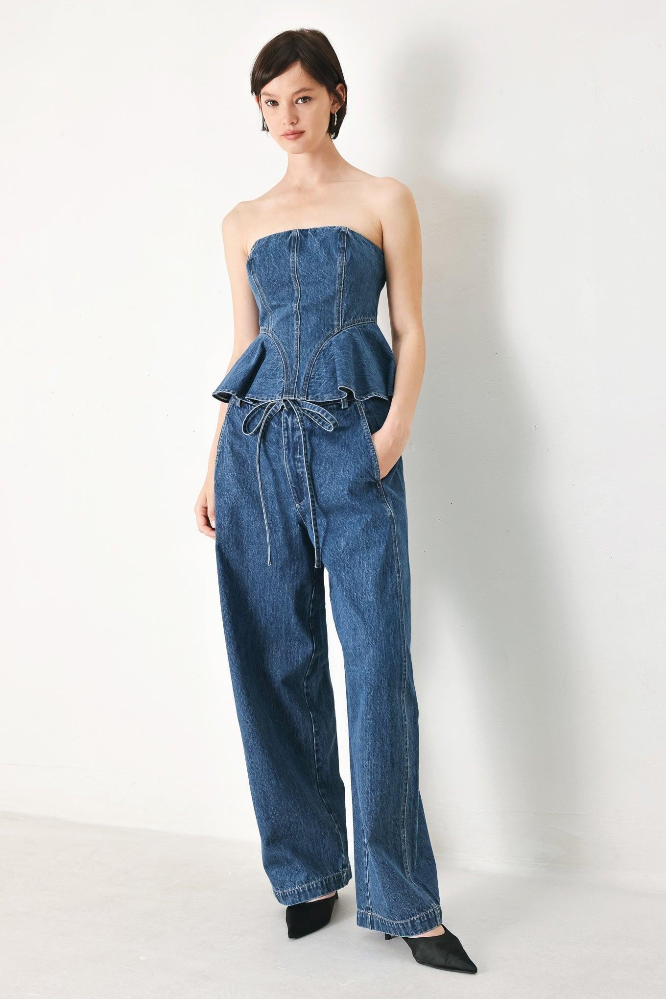A washed oversized denim pant featuring front closure, side/back pockets and wide leg