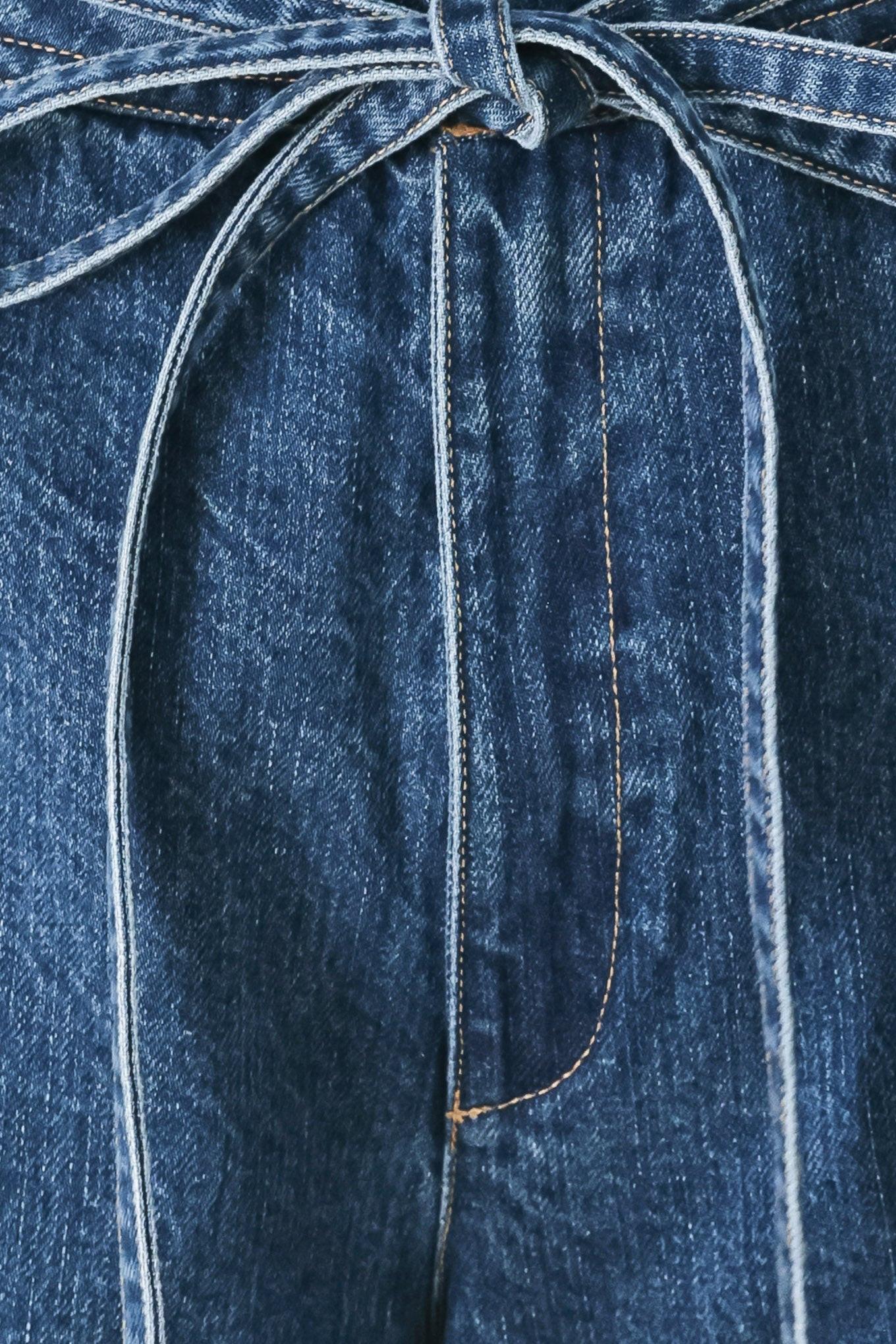 Close-up of a blue denim fabric with a tie, focusing on texture and pattern.