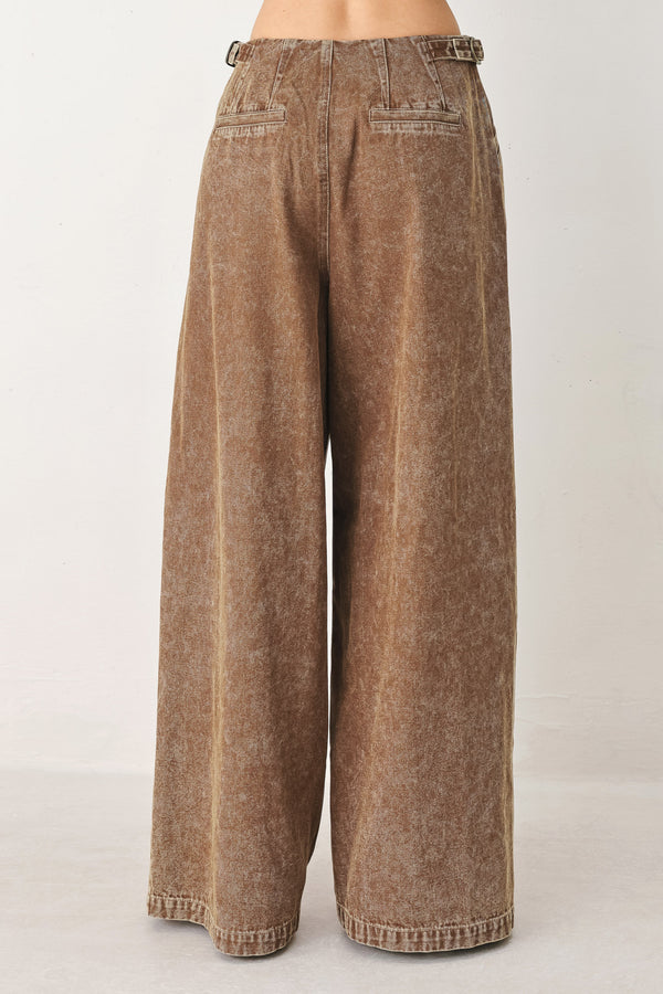Woman wearing a washed brown denim pant featuring front closure, pockets and side buckle detail at waist | FREEMAKET