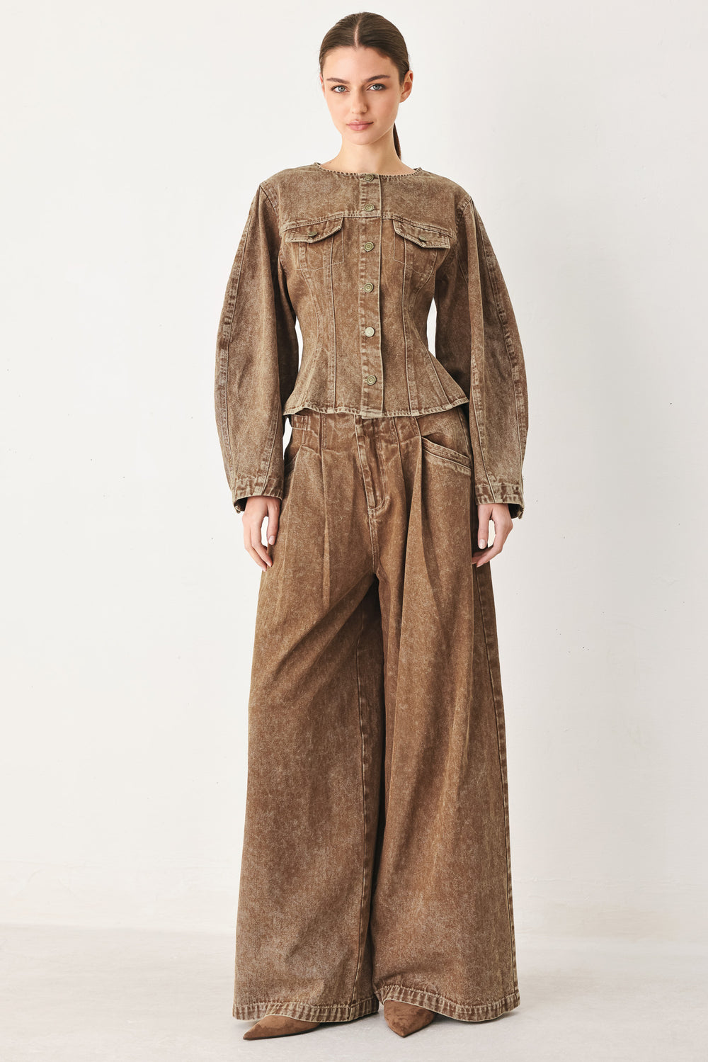 Woman wearing a washed brown denim pant featuring front closure, pockets and side buckle detail at waist | FREEMAKET