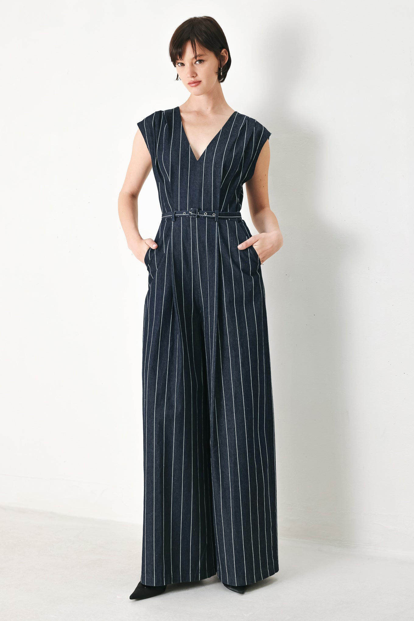 A striped woven jumpsuit featuring V neckline, short sleeve, self skinny belt, wide leg and back zipper closure