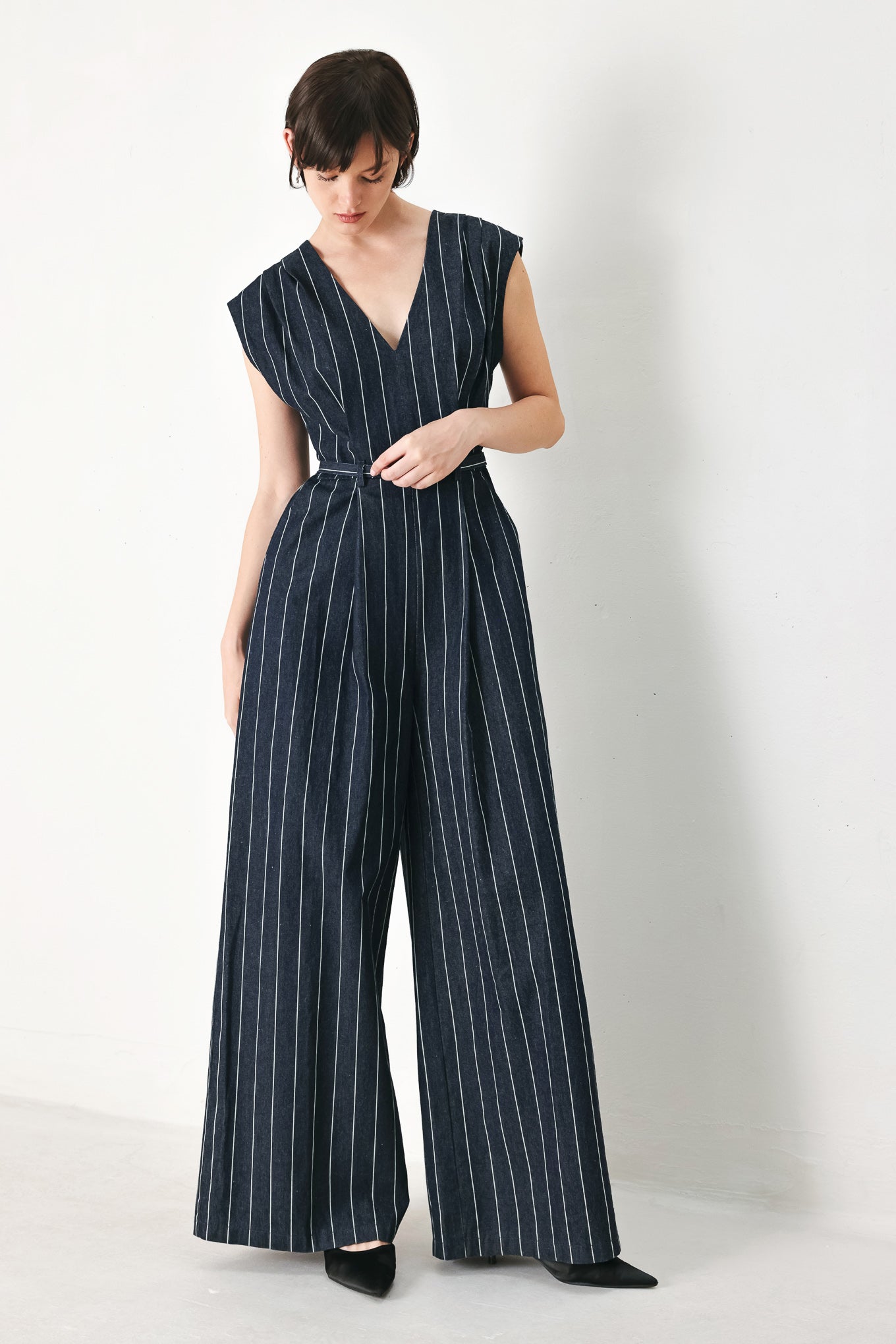 A striped woven jumpsuit featuring V neckline, short sleeve, self skinny belt, wide leg and back zipper closure