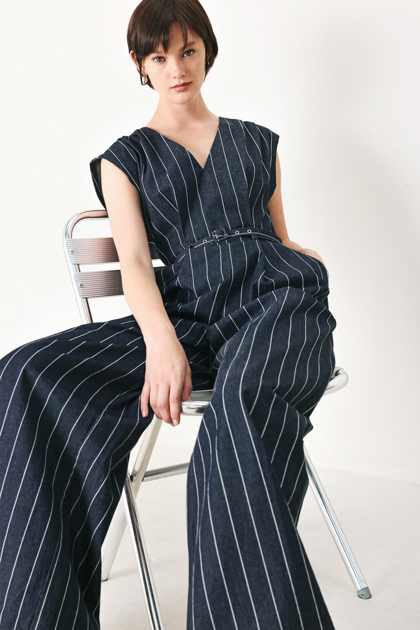 A striped woven jumpsuit featuring V neckline, short sleeve, self skinny belt, wide leg and back zipper closure