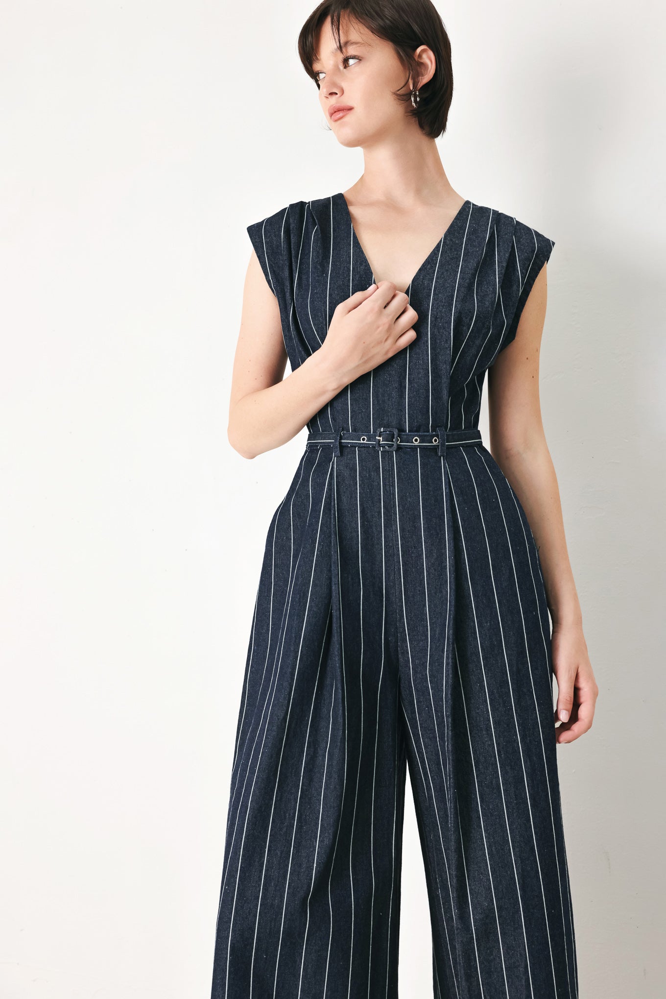 A striped woven jumpsuit featuring V neckline, short sleeve, self skinny belt, wide leg and back zipper closure
