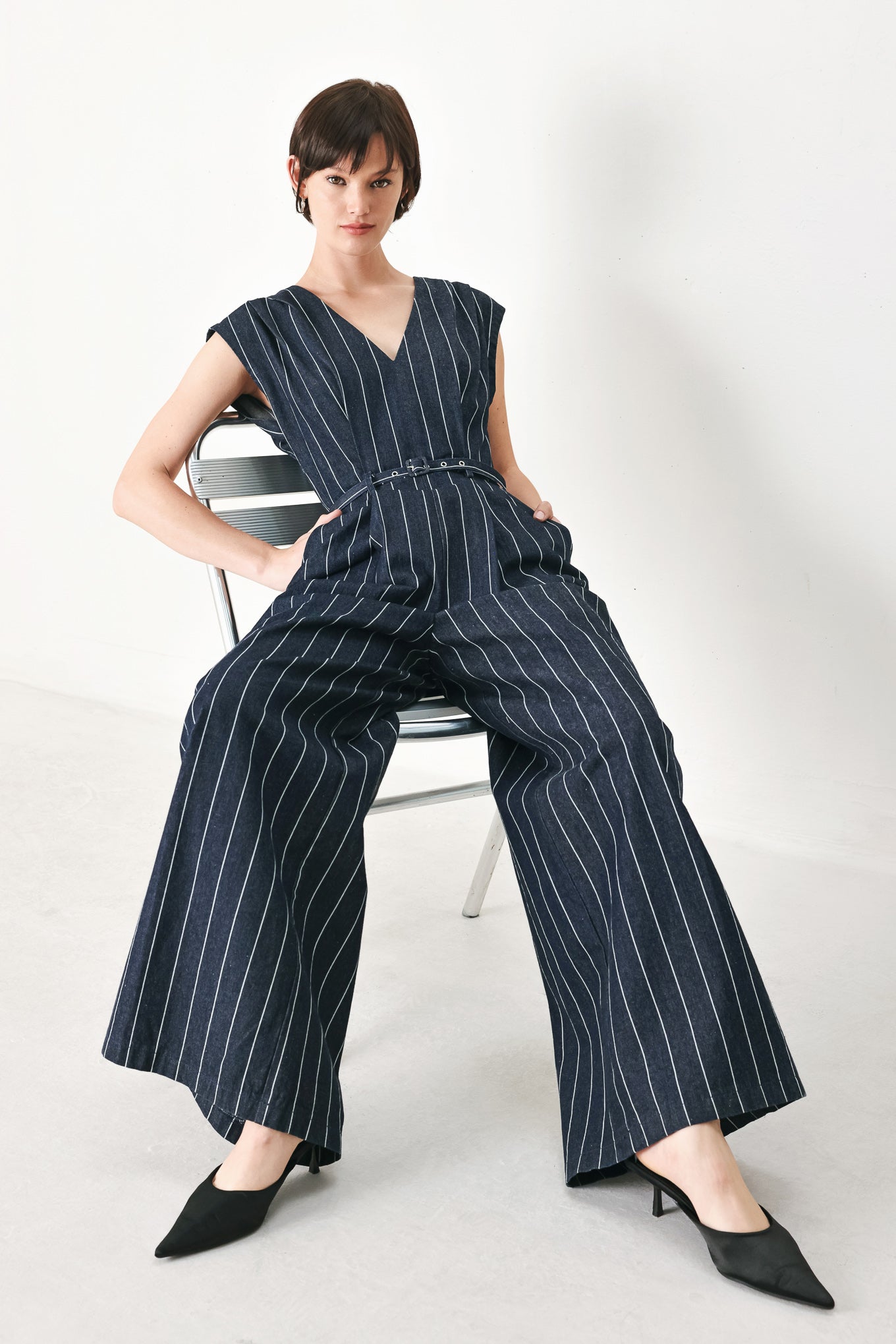 A striped woven jumpsuit featuring V neckline, short sleeve, self skinny belt, wide leg and back zipper closure