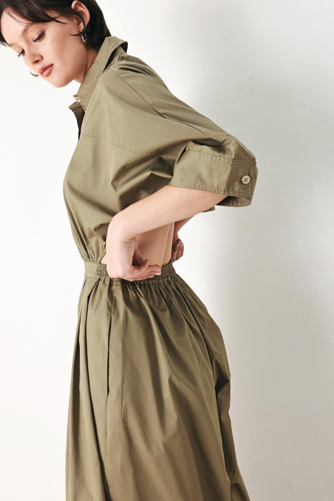 A solid woven matching utility-style jumpsuit consisting of a cropped, button-up shirt and high-waisted, wide-leg trouser