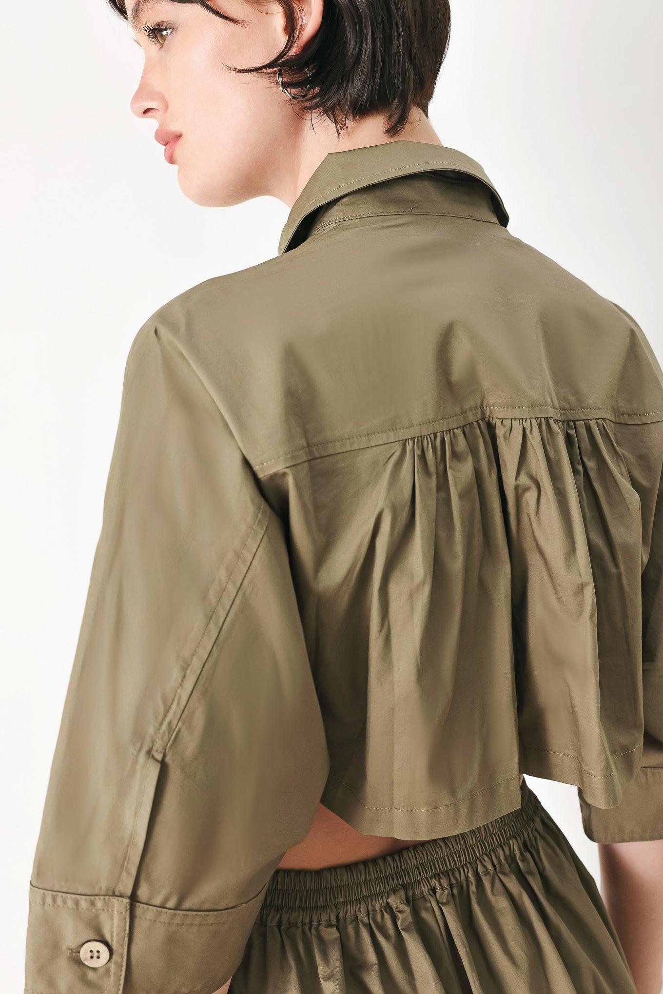 A solid woven matching utility-style jumpsuit consisting of a cropped, button-up shirt and high-waisted, wide-leg trouser