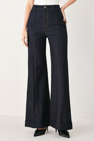 Woman wearing dark flared leg denim pants with front closure and cuff hem | FREEMARKET