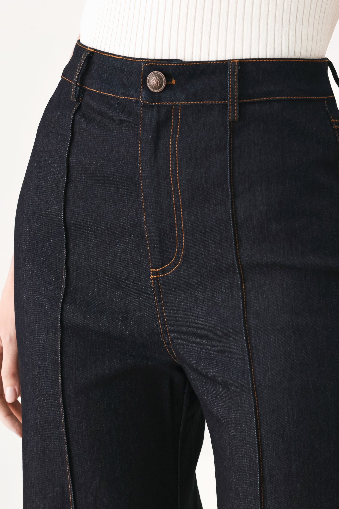 Woman wearing dark flared leg denim pants with front closure and cuff hem | FREEMARKET