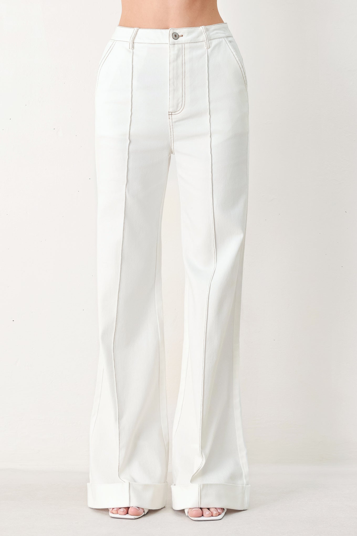 Woman wearing white wide-leg pants with a seam down the middle of each leg | FREEMARKET