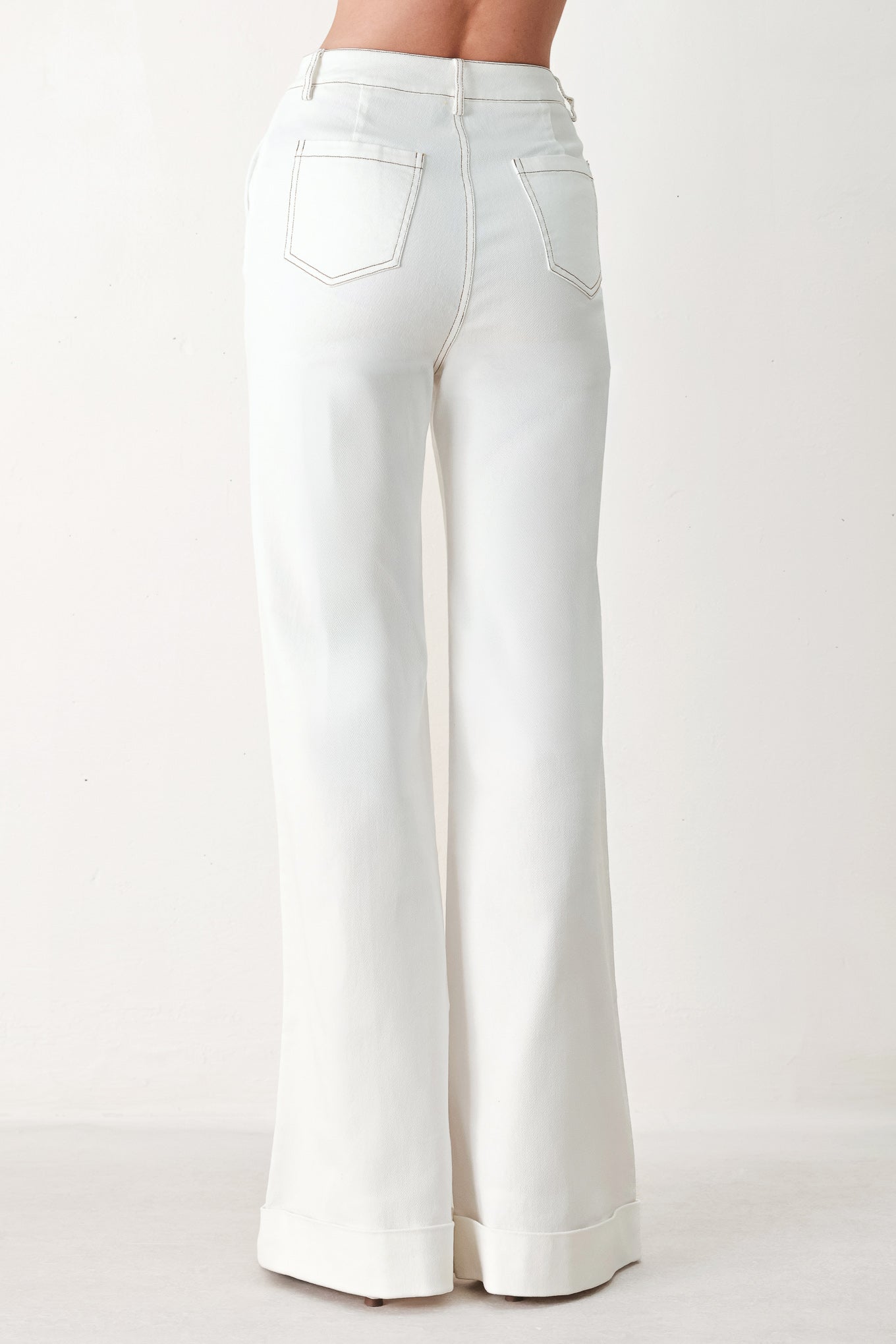 Woman wearing white wide-leg pants with a seam down the middle of each leg | FREEMARKET