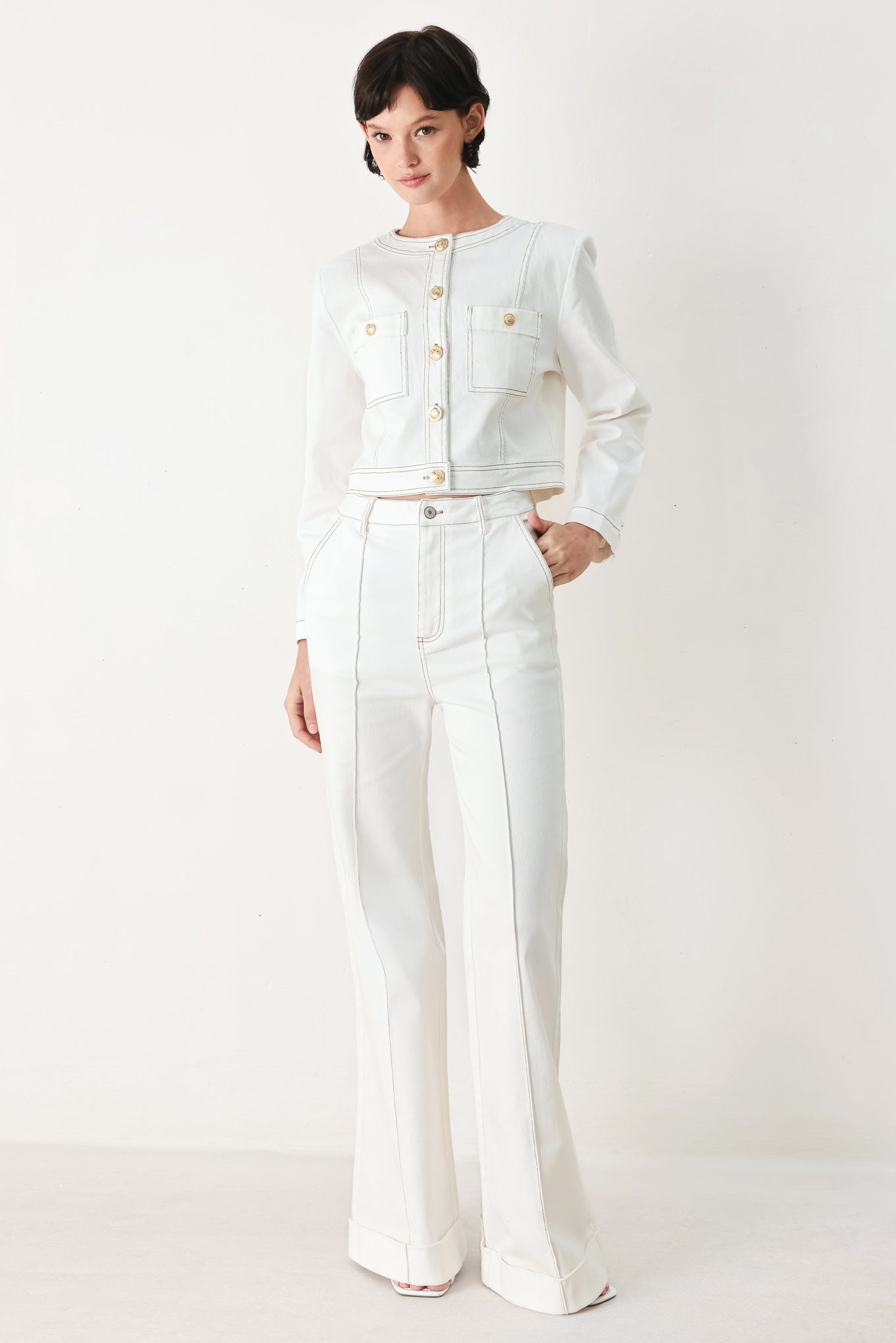 Woman wearing white wide-leg pants with a seam down the middle of each leg | FREEMARKET