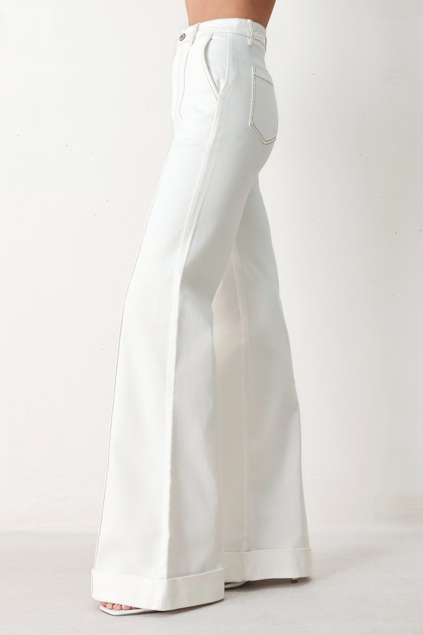 Woman wearing white wide-leg pants with a seam down the middle of each leg | FREEMARKET