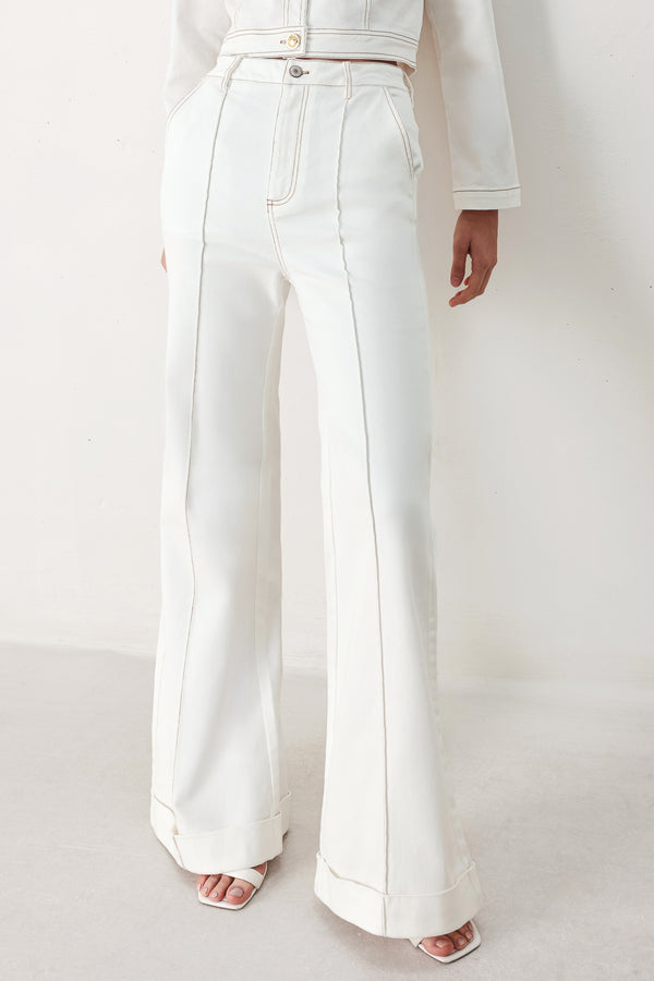 Woman wearing white wide-leg pants with a seam down the middle of each leg | FREEMARKET